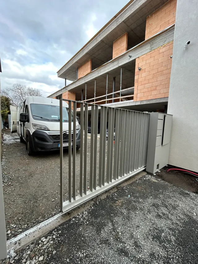 Kovová vjazdová brána v sivom prevedení